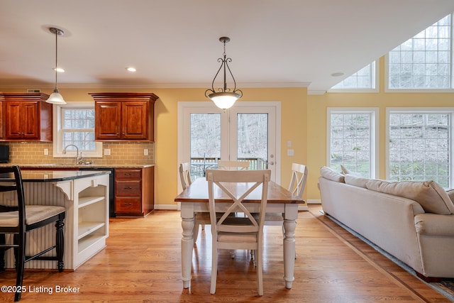 dining room with light wood-style flooring, baseboards, crown molding, and recessed lighting