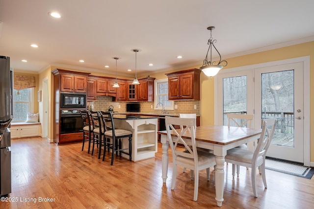 dining room featuring ornamental molding, recessed lighting, and light wood finished floors