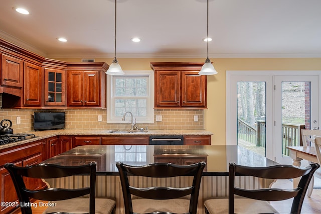 kitchen with a breakfast bar area, black gas stovetop, a sink, and dishwashing machine