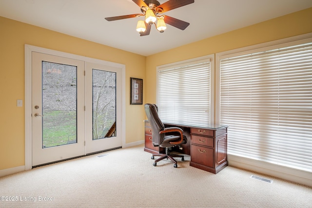 home office featuring a ceiling fan, visible vents, light carpet, and baseboards