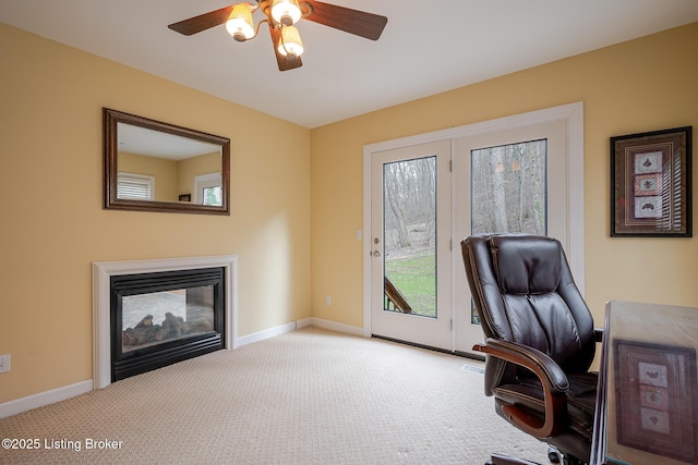 office space featuring carpet floors, baseboards, ceiling fan, and a multi sided fireplace