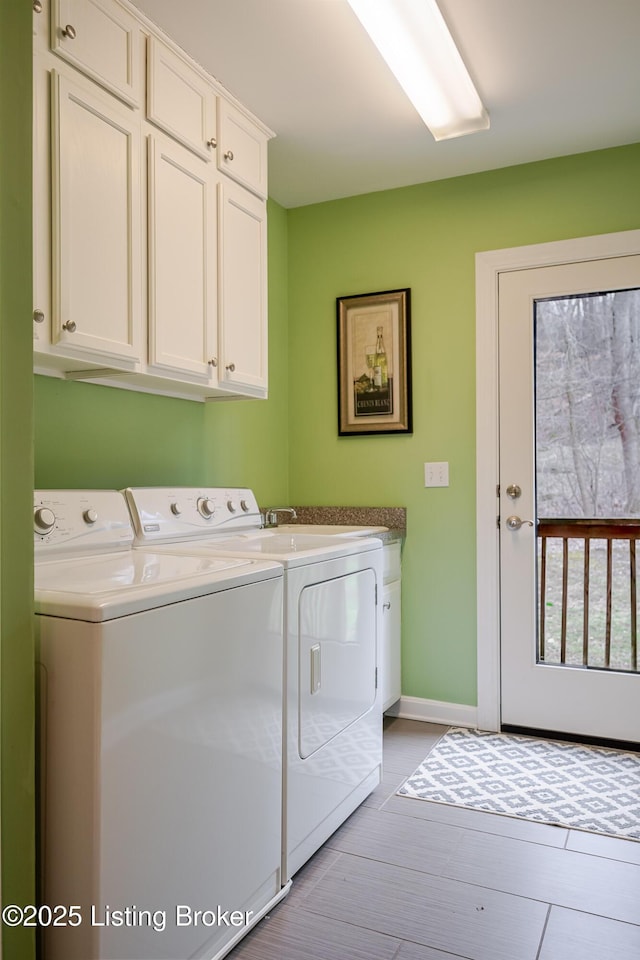 laundry room with washer and dryer, cabinet space, and baseboards