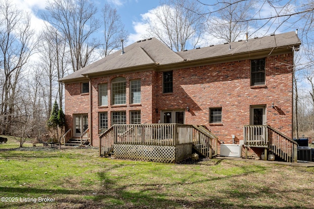 back of house with a deck, a lawn, and brick siding