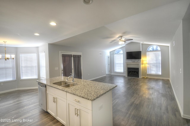 kitchen with sink, white cabinetry, light stone counters, hanging light fixtures, and dishwasher