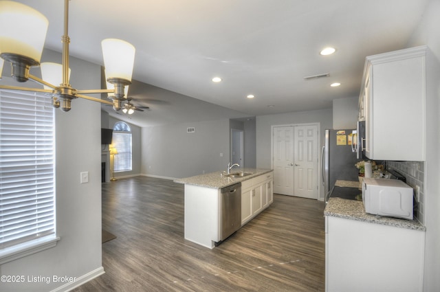 kitchen featuring white cabinetry, stainless steel appliances, dark hardwood / wood-style flooring, and light stone counters