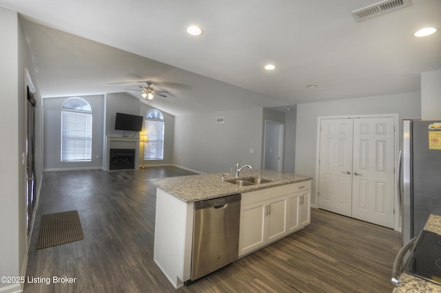 kitchen with appliances with stainless steel finishes, white cabinetry, sink, dark hardwood / wood-style flooring, and a kitchen island with sink