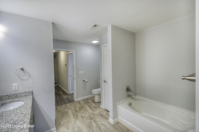 bathroom with vanity, toilet, and a bath