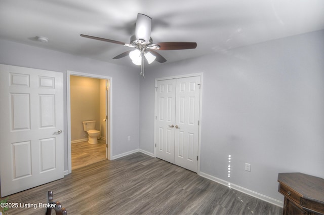 unfurnished bedroom with ceiling fan, dark hardwood / wood-style flooring, and a closet