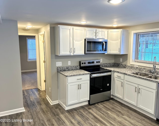 kitchen featuring stainless steel appliances, white cabinetry, and sink