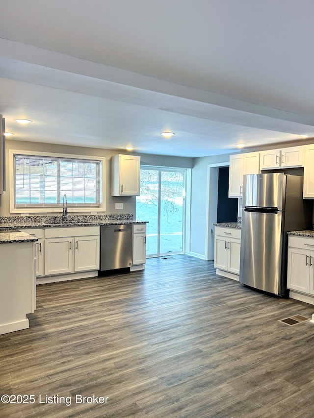 kitchen with appliances with stainless steel finishes, dark wood-type flooring, sink, and white cabinets