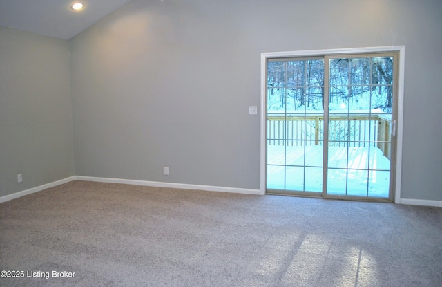 carpeted spare room featuring vaulted ceiling