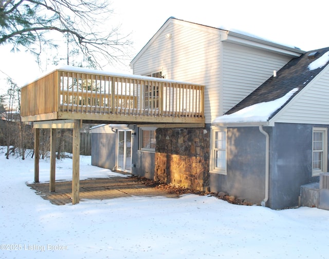 snow covered house with a deck