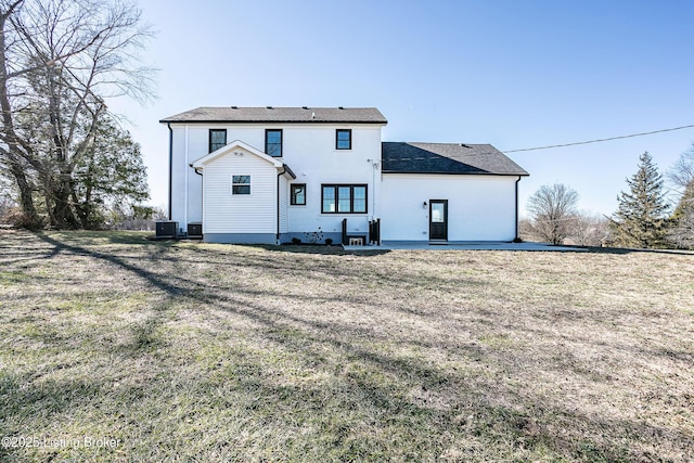 rear view of property featuring a yard, central AC, and a patio area