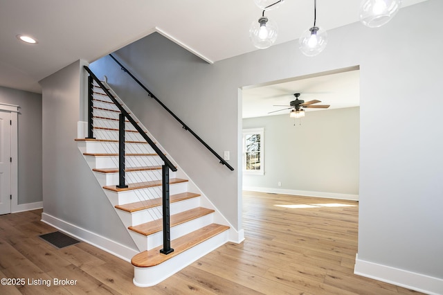 stairway featuring hardwood / wood-style flooring and ceiling fan