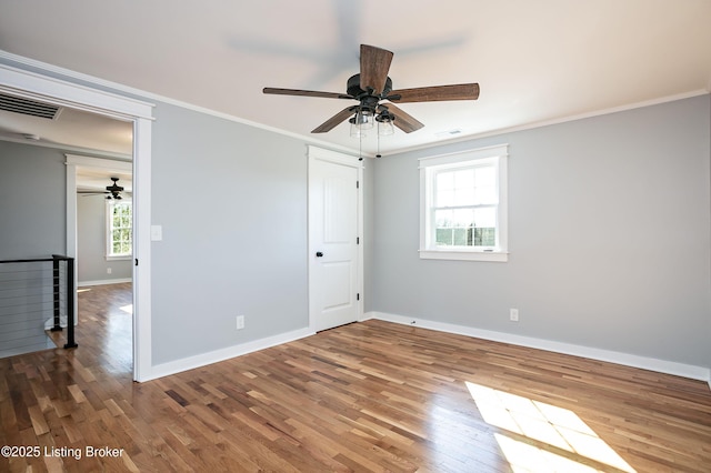 unfurnished bedroom with hardwood / wood-style flooring, ornamental molding, and multiple windows