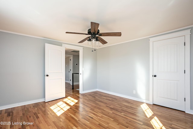 unfurnished bedroom featuring crown molding, ceiling fan, and hardwood / wood-style flooring