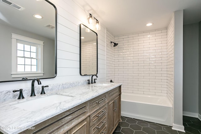 bathroom with tiled shower / bath, vanity, and tile patterned flooring