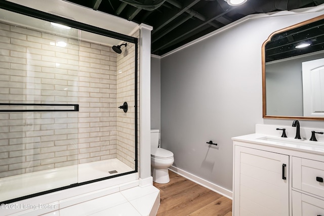 bathroom with vanity, toilet, a shower with shower door, and hardwood / wood-style floors