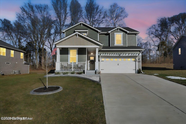 craftsman house with a garage, a lawn, and a porch