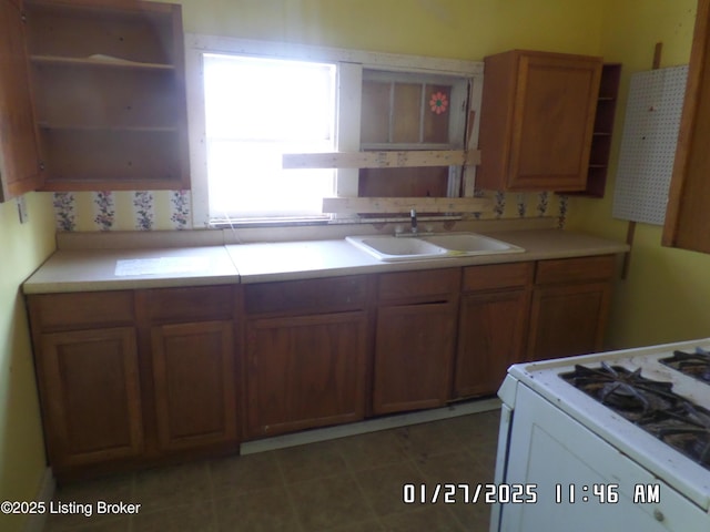 kitchen with sink, decorative backsplash, and gas range gas stove