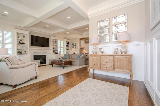 living room with coffered ceiling, ornamental molding, dark hardwood / wood-style flooring, built in features, and beamed ceiling