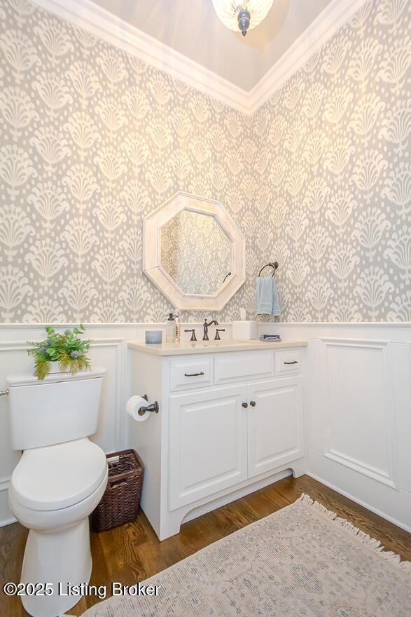 bathroom with ornamental molding, vanity, toilet, and hardwood / wood-style floors