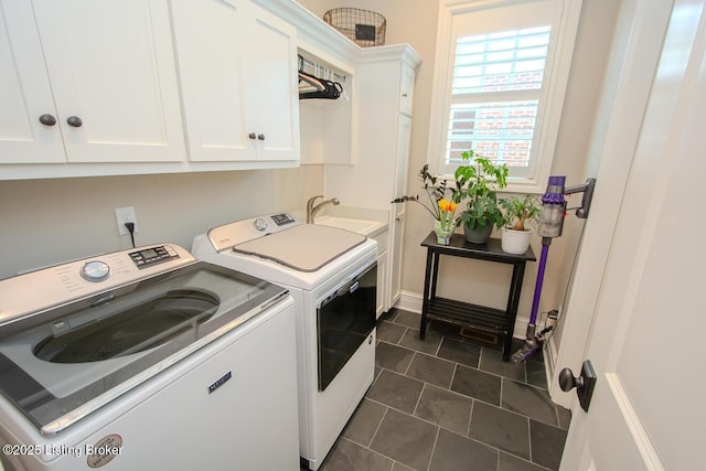 laundry room with sink, cabinets, washing machine and clothes dryer, and dark tile patterned flooring