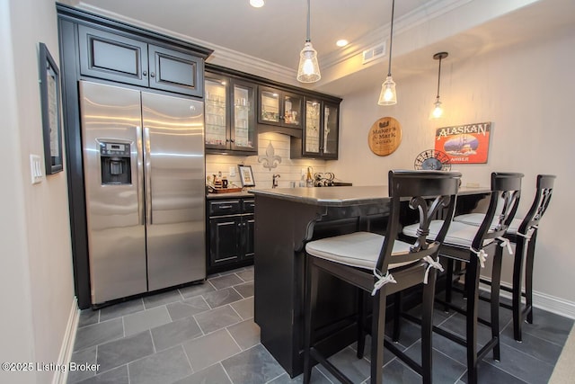 bar featuring crown molding, stainless steel fridge with ice dispenser, decorative light fixtures, and decorative backsplash