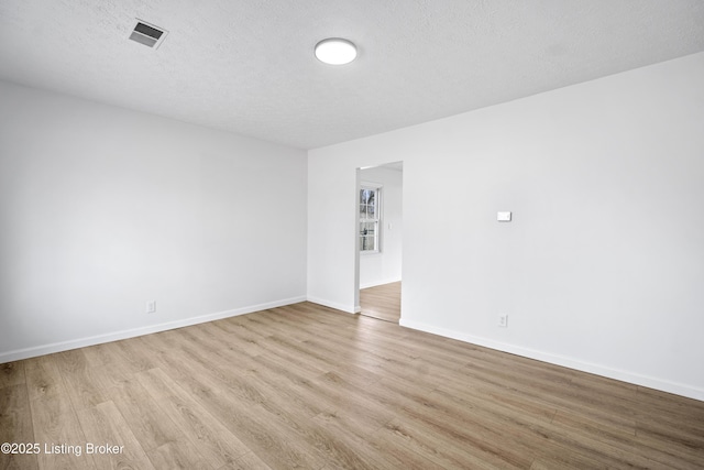 unfurnished room featuring light hardwood / wood-style flooring and a textured ceiling