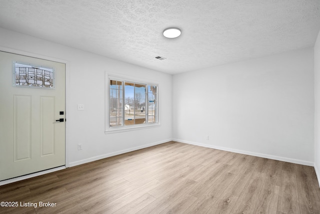 entryway with light hardwood / wood-style flooring and a textured ceiling