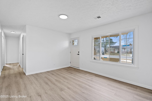 entrance foyer featuring a textured ceiling and light wood-type flooring