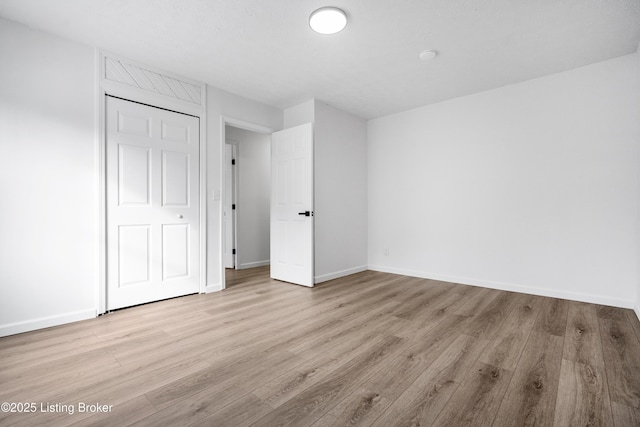 unfurnished bedroom featuring light hardwood / wood-style floors and a closet