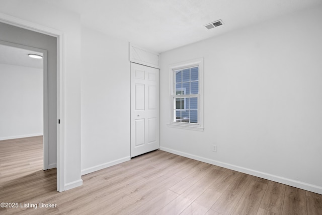 unfurnished bedroom featuring a closet and light hardwood / wood-style flooring