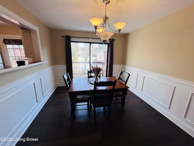 dining space with dark hardwood / wood-style flooring and a chandelier