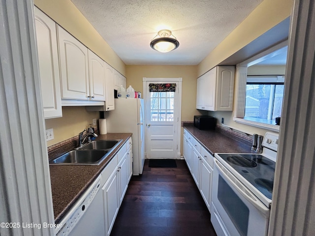 kitchen with white appliances, sink, and white cabinets