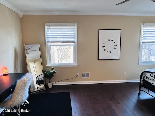 living area featuring dark wood-type flooring, a healthy amount of sunlight, ornamental molding, and ceiling fan