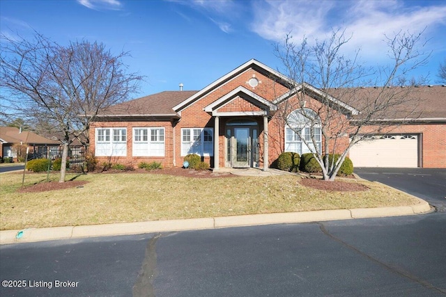 ranch-style home with driveway, an attached garage, a front lawn, and brick siding