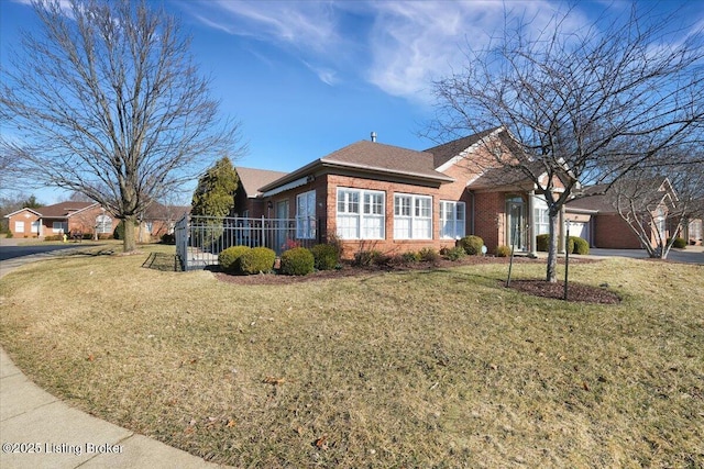 single story home featuring brick siding, a front lawn, and an attached garage