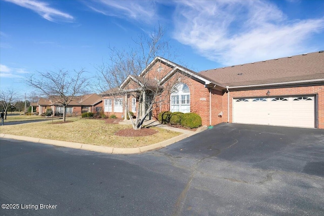 single story home featuring a garage, brick siding, driveway, and a front lawn