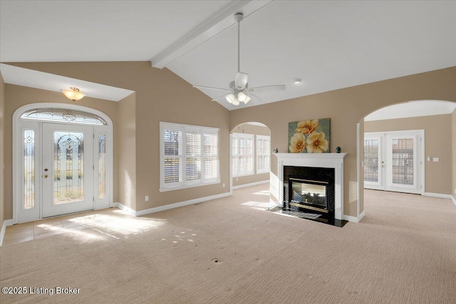 unfurnished living room featuring a premium fireplace, carpet flooring, beam ceiling, and baseboards