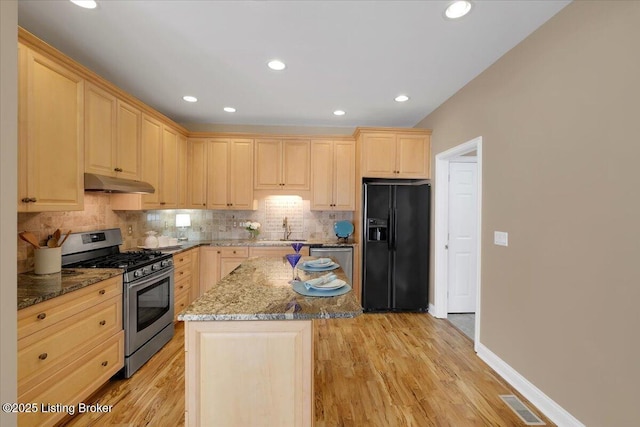 kitchen with under cabinet range hood, appliances with stainless steel finishes, and light brown cabinetry