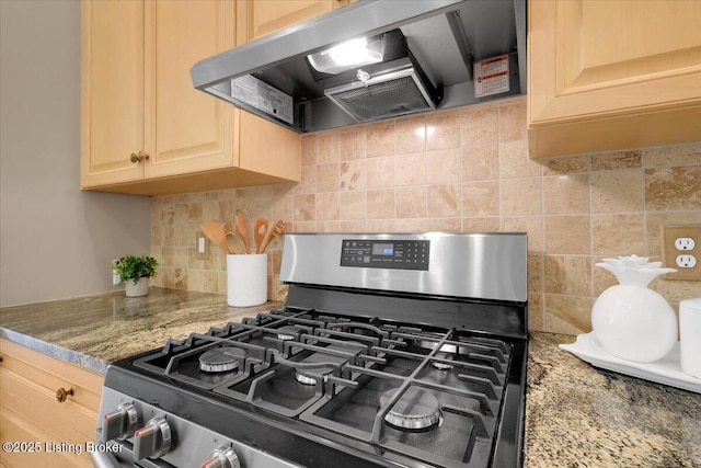 interior details featuring range hood, decorative backsplash, light brown cabinetry, light stone countertops, and gas range