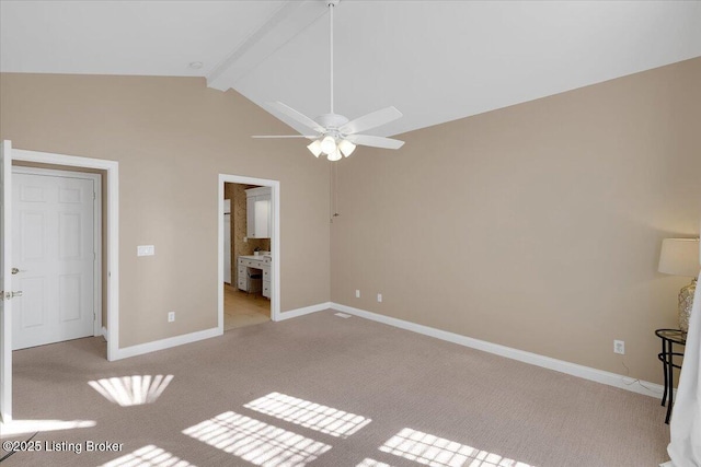 unfurnished bedroom with connected bathroom, light colored carpet, vaulted ceiling with beams, and baseboards