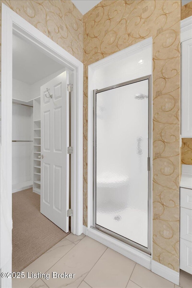 full bathroom featuring a stall shower, baseboards, and wallpapered walls