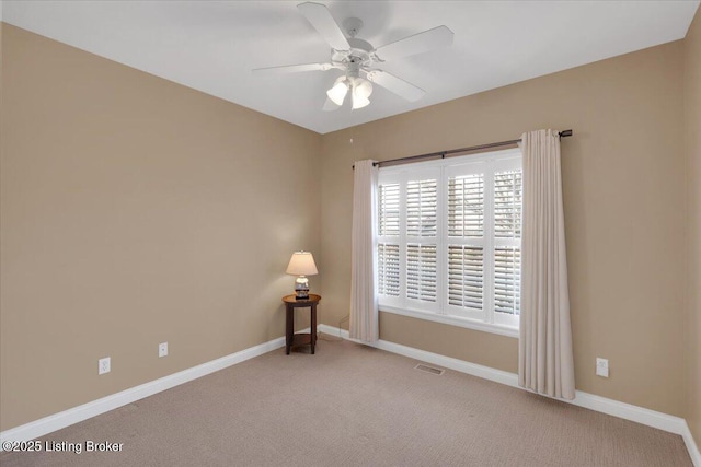 carpeted empty room with ceiling fan, visible vents, and baseboards