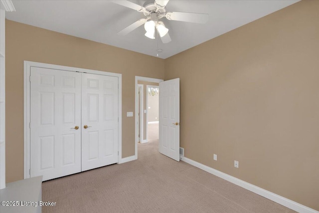 unfurnished bedroom featuring carpet floors, ceiling fan, baseboards, and a closet