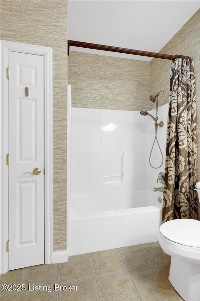 bathroom featuring shower / bath combo with shower curtain, toilet, and tile patterned floors