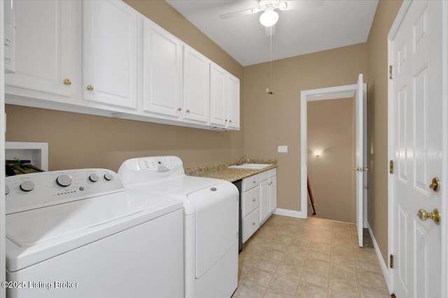 laundry room featuring cabinet space, washing machine and dryer, a sink, ceiling fan, and baseboards