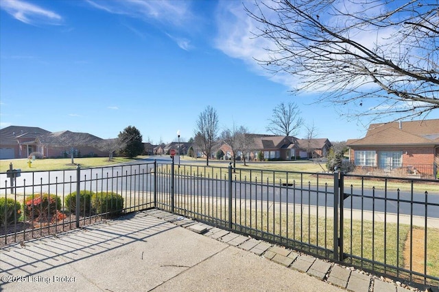 view of gate with fence and a residential view