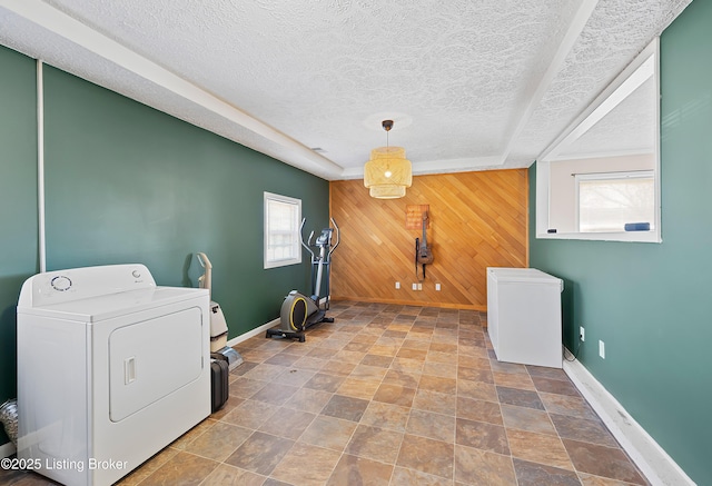 laundry room with washer / dryer, wooden walls, a textured ceiling, and plenty of natural light